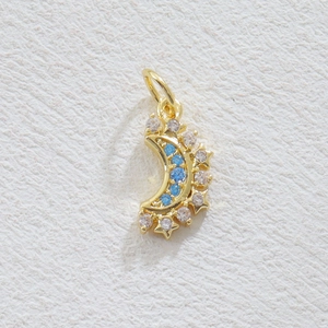Détail macro du pendentif lune et étoile plaqué or 18k avec pierres zircons bleus