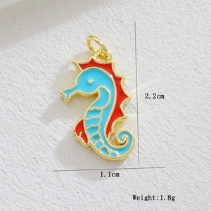 Macro shot of 2.2x1.1cm gold-plated seahorse pendant with blue and red enamel inlay