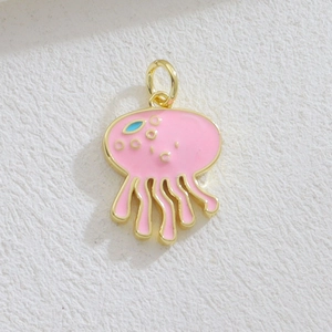 Detailed close-up of a pink jellyfish charm with gold edges and blue enamel dots