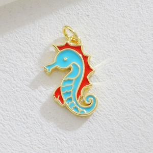 Macro view of seahorse pendant charm with light blue enamel and golden metal borders