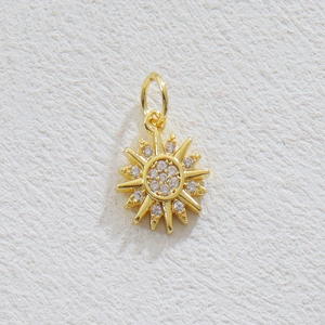 Détail du pendentif soleil plaqué or 18k orné de pierres de zircone blanches