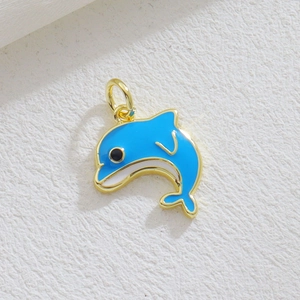 Macro view of a gold-plated dolphin pendant with blue and white enamel inlay detail