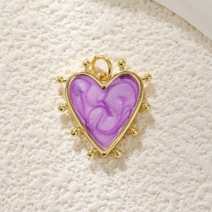Detailed macro view of heart charm with gold plating and purple marble enamel texture