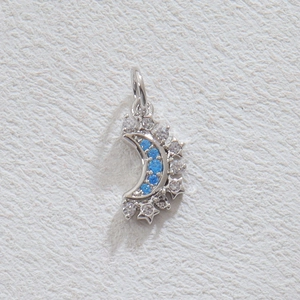 Macro du pendentif croissant de lune argenté serti de diamants bleus et cristaux blancs