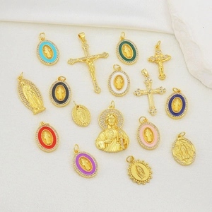 Detailed close-up of religious cross and virgin mary charms with colorful enamel inlay