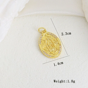 Close-up of a golden Virgin Mary pendant with sparkling cubic zirconia edges and size labels