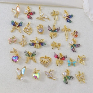 Detailed macro of assorted gold butterfly and heart charms with colorful zircon inlays