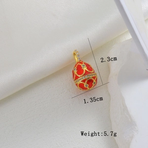 Detail view of Faberge style egg pendant with red enamel, gold heart patterns and crystals
