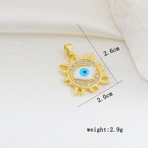 Macro shot of sun-shaped Evil Eye pendant in gold-plated copper with zircon accents