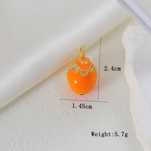 Detail view of orange enamel Easter egg pendant with cubic zirconia and gold plating