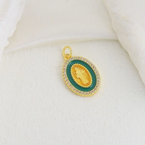 Macro detail of golden Virgin Mary oval pendant with green inlay and sparkling crystals