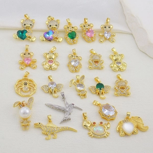 Macro shot of colorful zircon animal pendants including bears and dinosaurs in gold finish