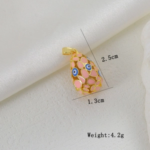 Close-up of pink enamel egg pendant with evil eye charms and dimensions 2.5x1.3cm