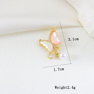 Detailed close-up of a butterfly pendant with pink shell wings and a dangling pearl drop
