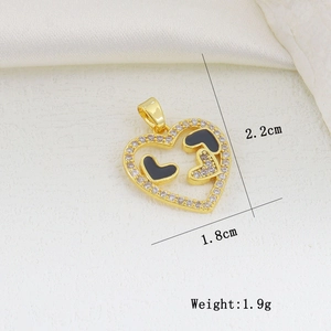 Detailed view of heart pendant with gold plating, white zircons and black enamel details