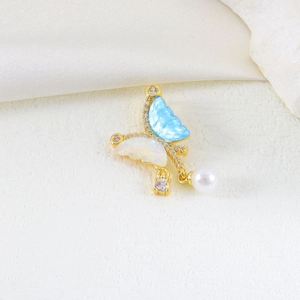 Detail of gold butterfly pendant with blue enamel, cubic zirconia and white pearl