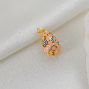 Detail of pink enamel teardrop pendant with blue evil eye motifs and golden plating