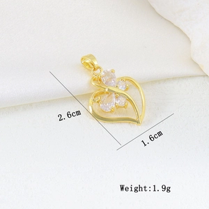 Macro detail of 18K gold heart pendant with zircon stones and dimensions 2.6cm x 1.6cm