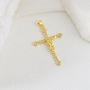 Detailed macro view of gold-plated Jesus cross pendant with white micro-pave zircons
