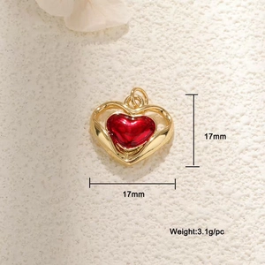 Macro detail of a 17mm gold heart pendant with red enamel and hollow metal frame