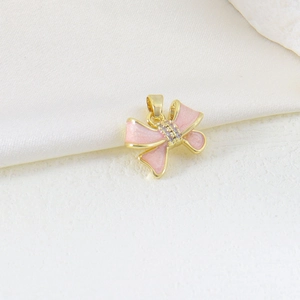 Macro view of gold butterfly pendant with pink enamel and sparkling zircon stones