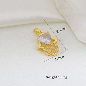 Macro shot of gold Hand of Fatima pendant with heart zircon and micro-paved crystals