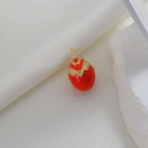 Macro shot of Easter egg pendant with red enamel, gold metalwork and micro-set zircons