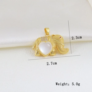 Detailed view of a gold elephant pendant with white heart stone and red gem eye detail
