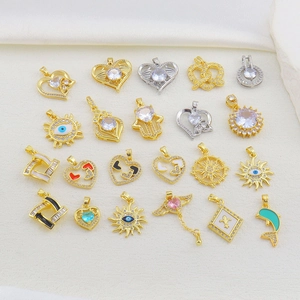 Detailed close-up of zircon-inlaid gold pendants with heart and evil eye designs