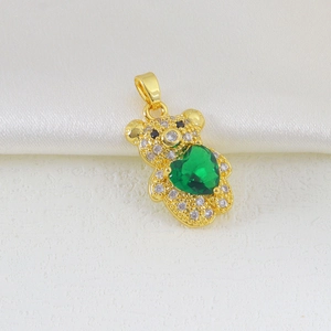 Close-up of a gold-plated bear pendant with white zircons and a green heart stone