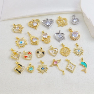 Flat lay of gold plated copper charms with colorful enamel and cubic zirconia inlays