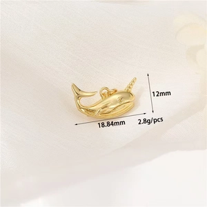 Makro-Detail des vergoldeten Narwal-Anhängers mit Maßen 18,84 mm mal 12 mm im Fokus