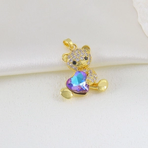 Detailed view of a gold bear pendant with zirconia inlay and a heart crystal