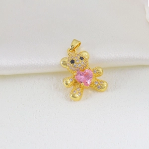 Detail of a golden bear pendant with paved white zircons holding a pink heart-shaped stone