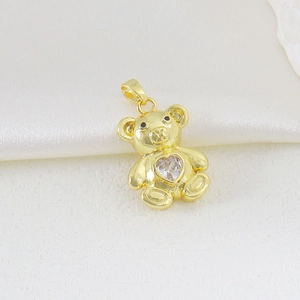 Macro detail of gold bear pendant featuring a sparkling heart-shaped cubic zirconia stone