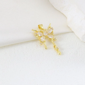 Detailed view of butterfly pendant with zircon inlay and water drop charm in gold finish