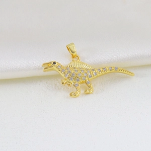 Macro view of gold dinosaur pendant with white zircon stones and black stone eye detail
