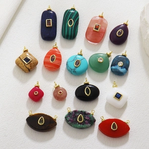 Detailed overhead view of assorted gemstone pendants with gold plated crystal settings