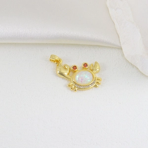 Close-up of golden crab pendant featuring iridescent opal-like stone and zircon accents