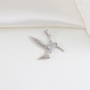 Detailed view of silver hummingbird pendant with micro-pave cubic zirconia and red gem eye
