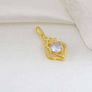Detailed macro view of a vintage gold hollow pendant with large round zircon center stone
