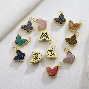 Macro detail of gold plated copper butterfly charms with colorful micro-set cubic zirconia