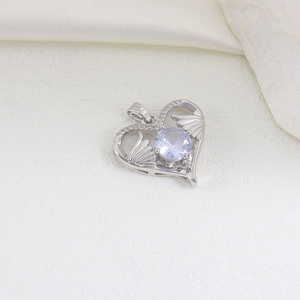 Macro detail of silver heart pendant with purple gemstone and delicate wing carvings