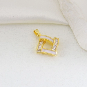Macro shot of gold-plated geometric pendant with white enamel and baguette zircon stones