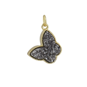 Detail of butterfly pendant with gold frame and sparkling dark grey crystal stones