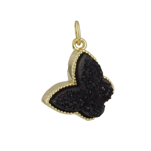 Detail of butterfly pendant with golden brass frame and black druzy crystal stone inlay
