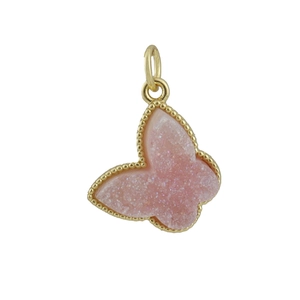 Macro shot of butterfly pendant with pink druzy stone and gold milgrain edge