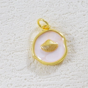 Detail of 18K gold plated shell pendant with mother of pearl inlay on white stone surface
