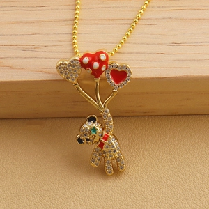 Detailed macro view of a gold bear pendant holding heart balloons with sparkling rhinestones