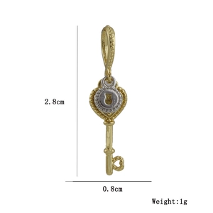 Macro detail of a 2.8cm vintage gold key pendant with zircon inlays and measurements